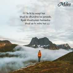 a person standing on top of a hill with clouds in the air and mountains behind them