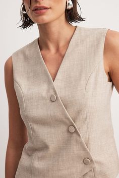 Asymmetric Buttoned Vest Beige | NA-KD V-neck Vest With Button Closure For Business Casual, Beige V-neck Vest For Work, Beige V-neck Tank Top For Work, V-neck Sweater Vest With Button Closure For Work, V-neck Vest For Business Casual In Spring, V-neck Vest For Business Casual Spring, Chic V-neck Vest With Buttons, Classic Beige Sleeveless Tank Top, Classic V-neck Vest With Buttons