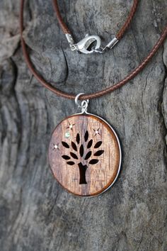 "This beautiful and unique hand-carved Tree wooden necklace will be made for you, or a loved one, in my studio on the West of Ireland. Encircled into a side groove with a sterling silver ring and adorned with abalone shell & silver inlays, this delicately carved Tree of life pendant features a piece of rosewood, recycled from guitars constructed by a local luthier. As a musician myself, I take enormous satisfaction in creating a piece of jewellery whose inherent wood has previously featured Nature-inspired Carved Natural Jewelry, Natural Carved Necklaces As Gift, Holistic Wooden Beads Necklace As A Gift, Holistic Wooden Beads Necklace For Gift, Holistic Style Wooden Beads Necklace For Gifts, Holistic Style Necklace With Wooden Beads, Holistic Style Necklace With Wooden Beads For Gifts, Artisan Hand-tooled Necklace For Gift, Rustic Wooden Beads Necklace As Gift