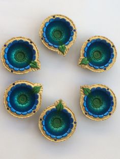 five blue and green dishes with leaves on them are arranged in a circle, one is empty