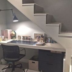 a desk under the stairs in a home office