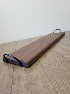 a wooden board with a black handle on it