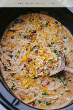 a crock pot filled with chicken, beans and cheese