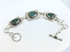 "I have bezel set 3 pieces of genuine Spanish Aqua sea glass using fine silver.  They are backed with hammered Argentium Sterling Silver sheet & attached to my hand crafted Argentium Sterling Silver links.  The closure is a hand fabricated wave design toggle clasp.  Bracelet is 8 1/4\" long.  Shown on 7\" wrist. All design & fabrication done by me. To find your wrist measurement, use a measuring tape wrapped around your wrist just above your wrist bone.  Add 1/2-1\", depending how loose you want Unique Silver Jewelry With Recycled Glass, Handmade Recycled Glass Bracelet, Seaglass Art, Toggle Clasp Bracelet, Sea Glass Bracelet, Clasp Bracelet, Sea Glass Art, Glass Bracelet, Silver Work