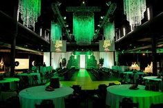 an indoor event venue with green lighting and chandeliers