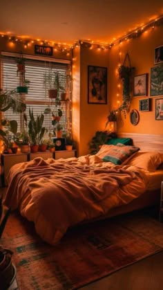 a bed room with a neatly made bed surrounded by potted plants and lights on the wall