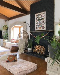 a living room filled with furniture and a fire place in the middle of a wooden floor