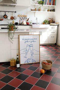 a kitchen with red and black tile flooring next to a basket of oranges