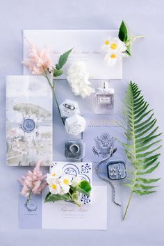 an assortment of flowers and other items on top of a white surface with blue accents