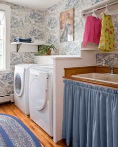 a washer and dryer in a room with floral wallpaper on the walls