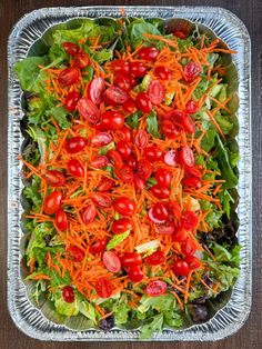 a salad with carrots, lettuce and tomatoes