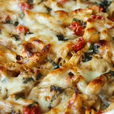 a casserole dish with spinach, cheese and tomatoes on it's side