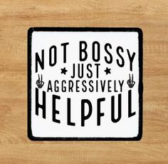 a sticker that says not bossy just aggressively helpful on a wooden surface