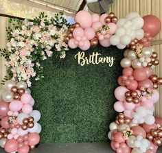 an arrangement of balloons and flowers are arranged in the shape of a heart