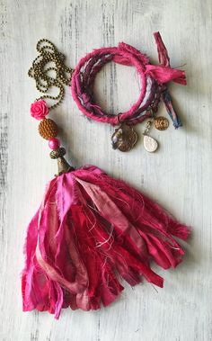 the pink tassel is next to two bracelets