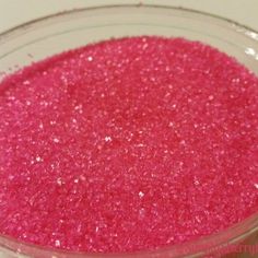 a bowl filled with pink glitter sitting on top of a table