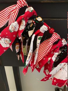 a bunch of red and white christmas ribbon hanging from a door handle with santa clause on it