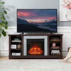 a flat screen tv sitting on top of a wooden stand next to a fire place