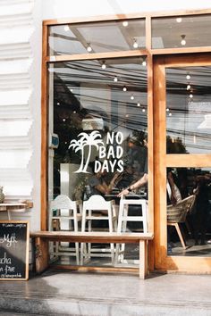 there is a sign in the window that says no bad days and chairs are outside