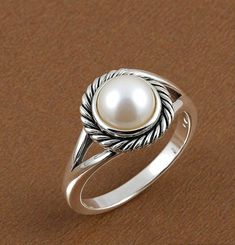 Add a touch of classic elegance to your look with our Round Pearl Silver Ring. This beautiful ring features a smooth, round pearl set in a sleek silver band. Its timeless design makes it perfect for everyday wear or special occasions. Crafted from high-quality silver, the ring showcases the pearl's natural shine, making it a lovely addition to any jewelry collection. Simple yet stunning, it's a perfect choice for a refined and sophisticated style. DETAILS---- 1) Material - 925 Silver 2) Gemstone Classic Pearl Ring With Pearl Drop, Classic Round Rings With Pearl Drop, Classic Round Pearl Ring With Pearl Drop, Timeless Silver Sterling Silver Pearl Ring, Timeless Sterling Silver Pearl Ring In Silver, Timeless Silver Pearl Ring In Sterling Silver, Classic Pearl White Open Ring Jewelry, Elegant Sterling Silver Pearl Ring, Fine Jewelry Pearl Ring With Round Band