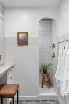 a bathroom with white walls and wood accents