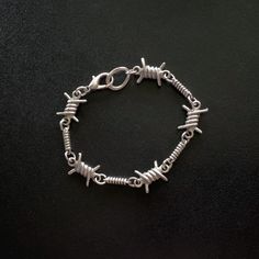 Silver plated, barbed wire design, chain bracelet with lobster clasp - Antique silver plated, brass, barbed wire and spring chain - Silver plated, lobster clasp - Lead and nickel safe *This bracelet was hand-tooled and provides plenty of space to add charms if you wish to do so. **All pieces are silver plated. Perfect as a layering piece, as it's substantial, while remaining sleek. Punk Style Chain Link Jewelry With Lobster Clasp, Adjustable Silver Punk Chain Bracelet, Edgy Adjustable Metal Chain Bracelet, Adjustable Edgy Metal Chain Bracelet, Adjustable Metal Punk Chain Bracelet, Adjustable Metal Chain Bracelet, Punk Style, Adjustable Silver Grunge Bracelet, Silver Metal Grunge Bracelets, Edgy Silver Metal Chain Bracelet