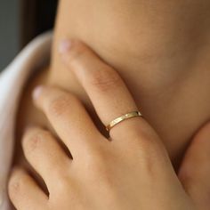 a woman's hand with a gold ring on it