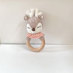 a crocheted deer ring rattler on a white surface