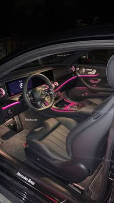 the interior of a car is lit up with pink lights