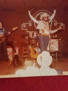 an old photo of two men on stage with guitars