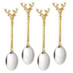 three spoons with gold antlers on them are lined up in a row against a white background