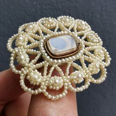 A beautiful mourning brooch, made of many seed pearls which have been finely entwined using clear wire, and are backed with a carved mother of pearl plaque. In the centre is a glass locket compartment, which houses a small lock of hair. The reverse shows a small portrait of a gentleman. With a gold pin and 'C' catch fitting.Circa late Georgian - early Victorian era.Unmarked, fittings tested as gold.The brooch measures approximately 39.2mm x 34.8mm.The glass locket compartment measures approximat Antique Wedding Brooch With Intricate Design, Antique Baroque Brooches For Wedding, Victorian Wedding Brooches With Intricate Design, Heirloom Wedding Brooches With Intricate Design, Antique Medallion Brooch For Wedding, Heirloom Cameo Brooch For Wedding, Heirloom Cameo Brooches For Weddings, Heirloom Cameo Wedding Brooch, Victorian Style Cameo Brooch For Weddings