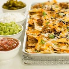 a casserole dish with tortilla chips, salsa and guacamole