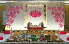 an elaborately decorated stage set up with pink flowers and decorations on the sidelines