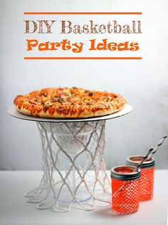 a pizza sitting on top of a white table next to two orange cups and a basket