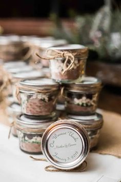 several jars filled with different types of food on top of a wooden table next to twine