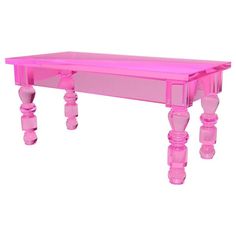 a pink table with wooden legs and an acrylic design on the top is shown