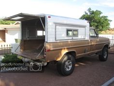 an old truck with a camper attached to the back