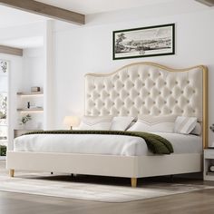 a white bed sitting in a bedroom on top of a hard wood floor