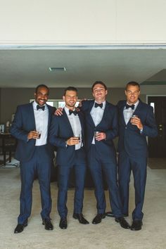 four men in tuxedos posing for the camera