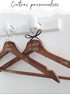 two wooden clothes hangers with white birds on them and the names of each pair