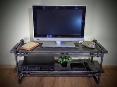 a computer monitor sitting on top of a metal shelf next to a keyboard and mouse