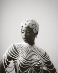 a woman with pearls on her dress and headdress