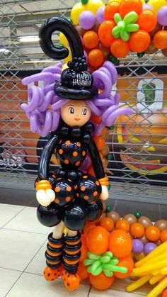 a halloween decoration in the shape of a girl with purple hair and pumpkins on her head