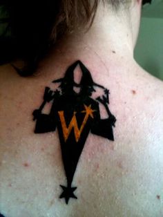 the back of a woman's neck with a star and letter tattoo on it