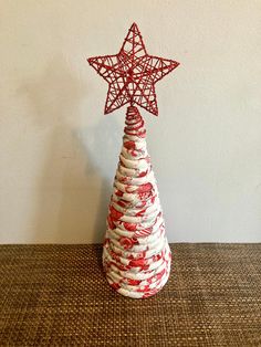 a small red and white christmas tree with a star on top