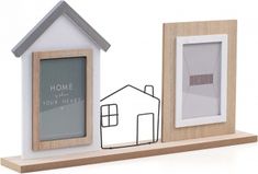 two small wooden frames are on a shelf with a house next to it and a window