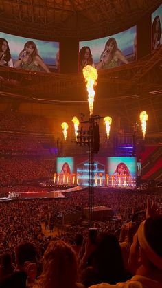 the crowd at a concert is watching two women on stage with torches in front of them