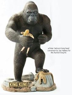 there is a statue of a gorilla holding a banana on top of a rock with the caption king kong