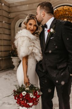 a bride and groom standing in the snow